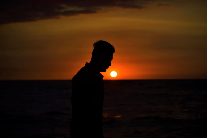 Image of a person with the sun setting in the background