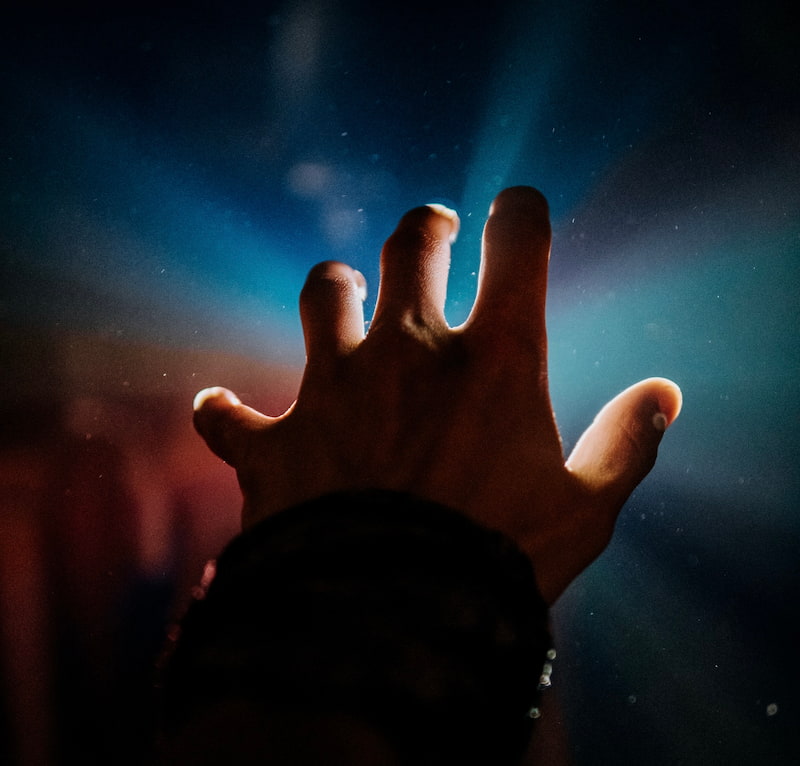 Image of a hand reaching out to the light during meditation symbolic of makyo